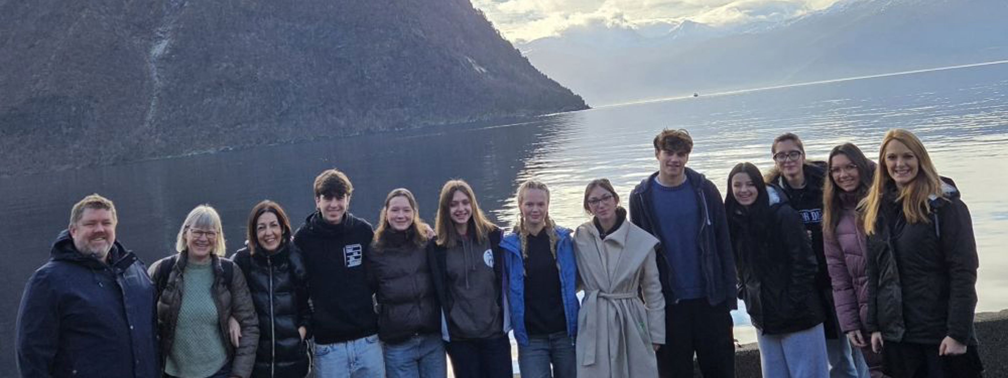 Elevar samlet på ei rekke med fjord og fjell i bakgrunnen