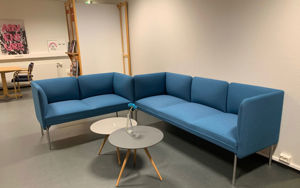Blå vinkelsofa inne på eit bibliotek