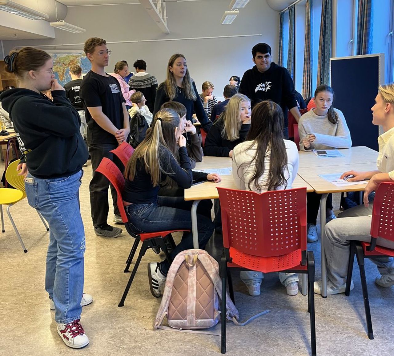 Fleire elevar er samla i eit klasserom for å diskutere klima