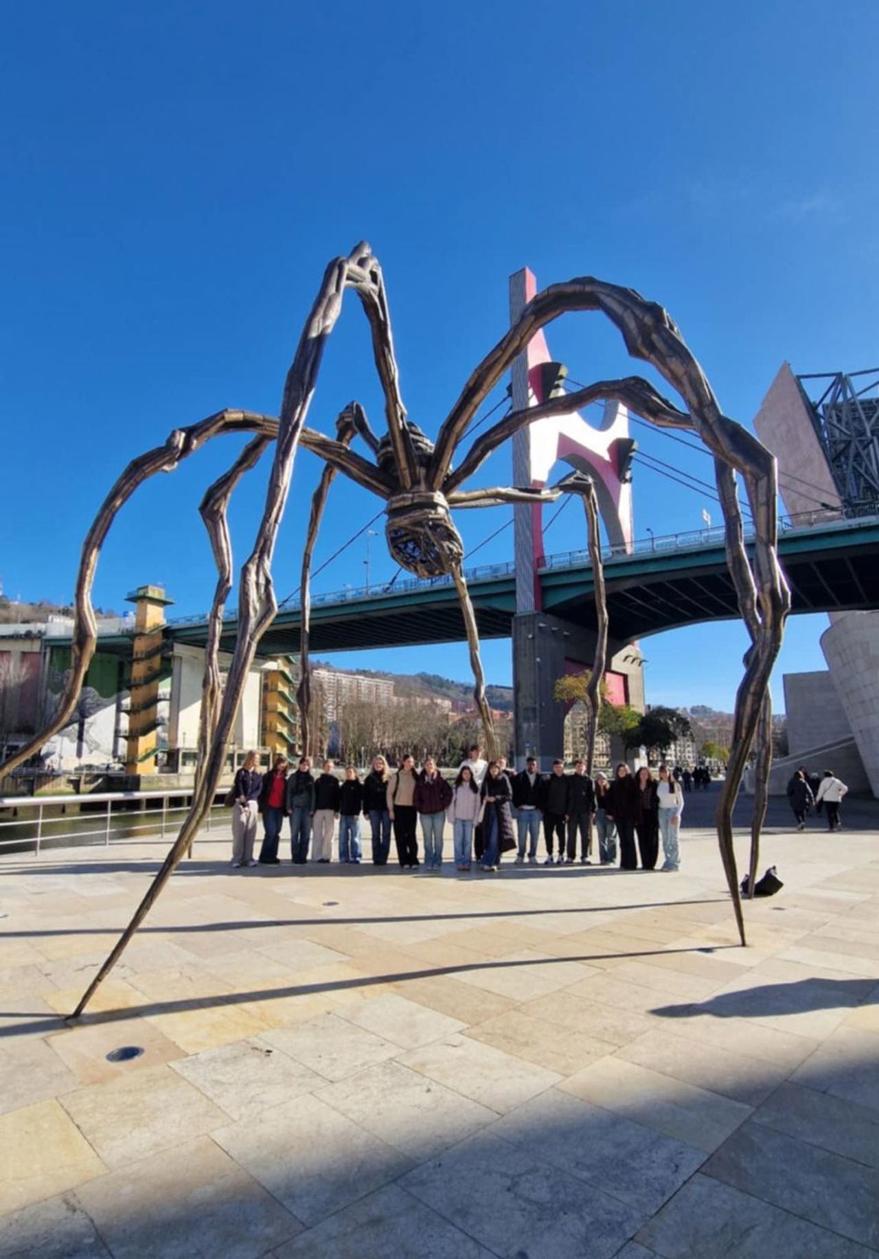 Deltakarane står oppstilt under ein stor edderkopp utanfor Guggenheimmuseet